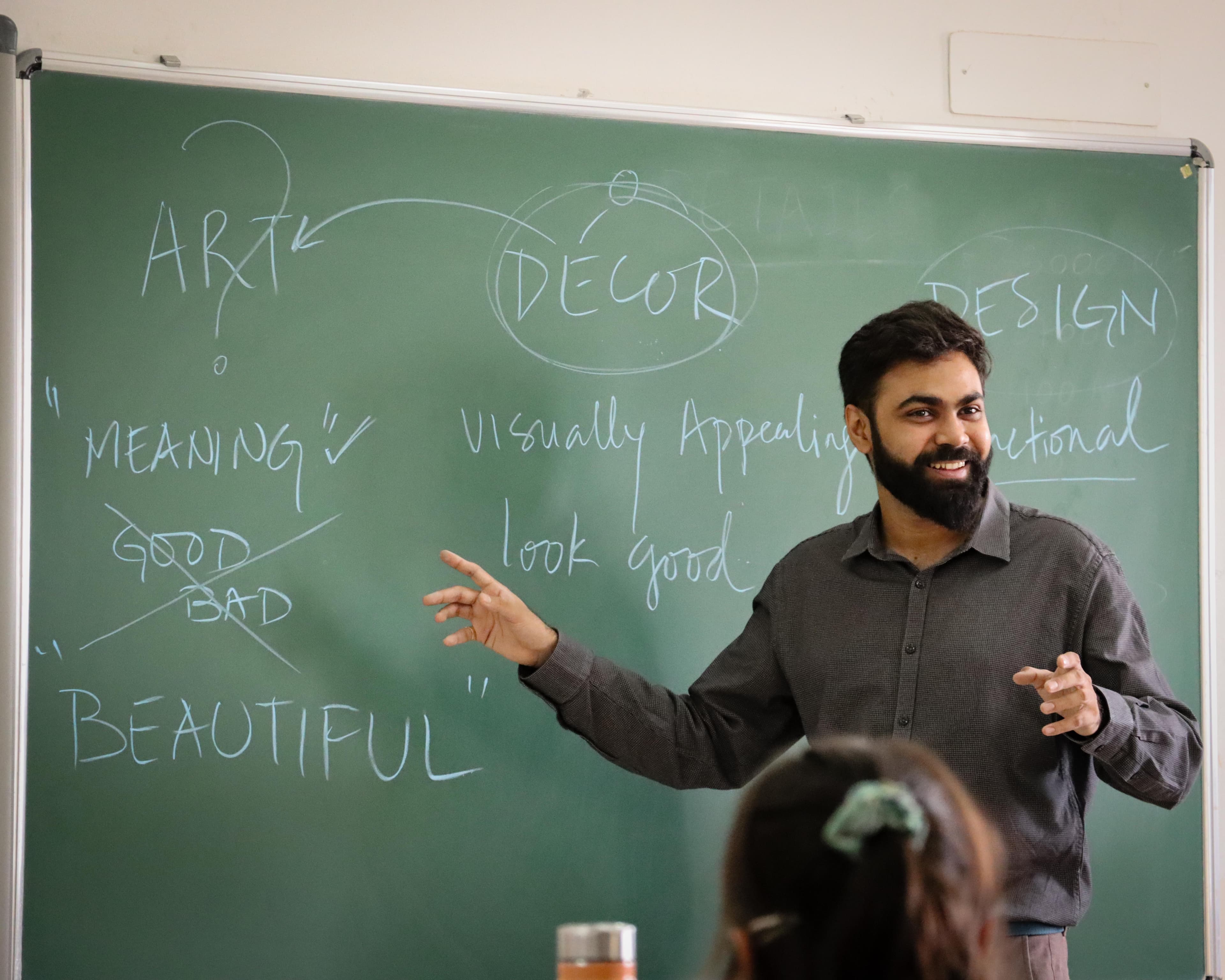 Anukrit Saxena teaching art concepts at a classroom board